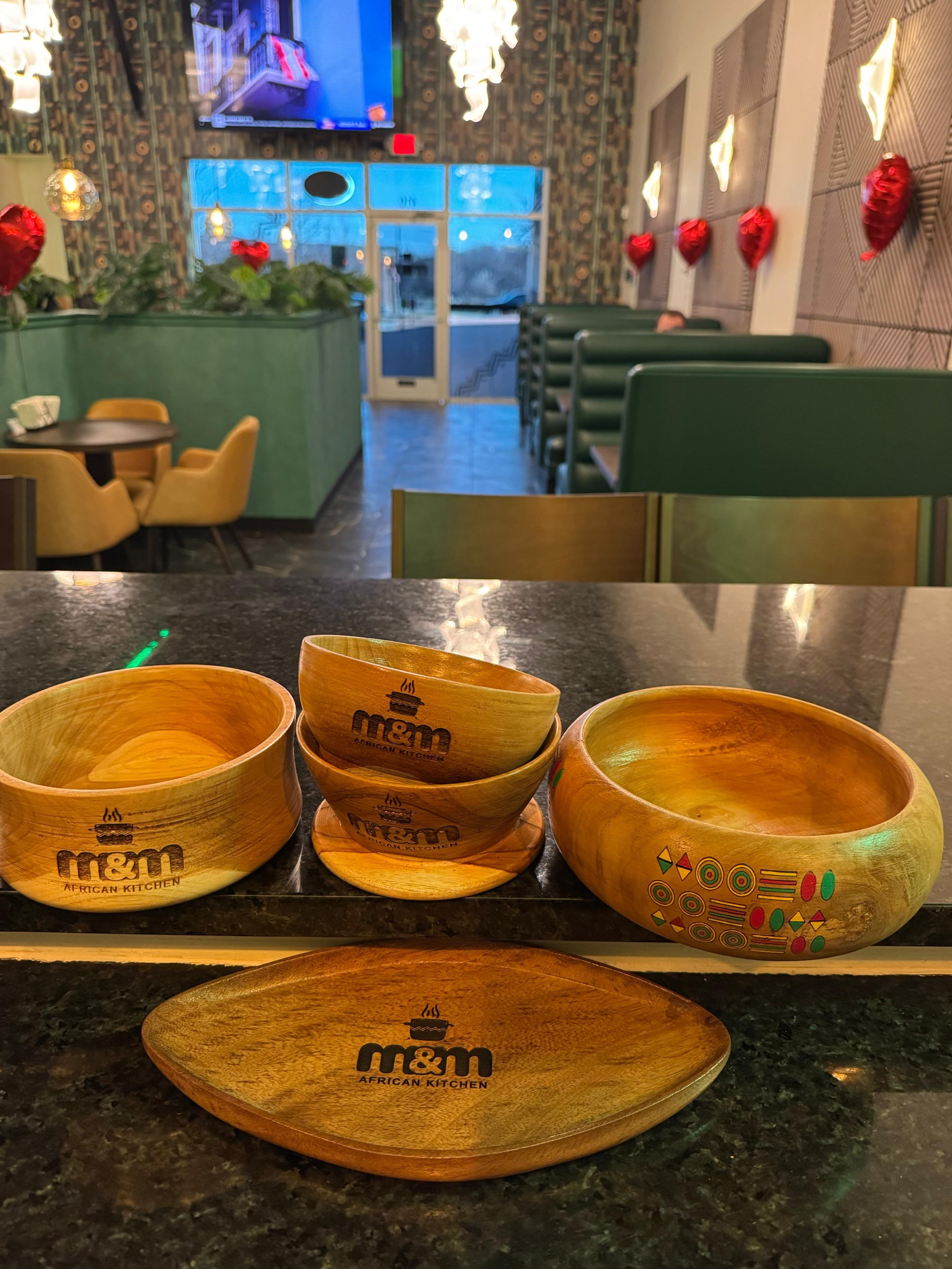 M&M African Kitchen dining room with branded serving bowls and green booth seating